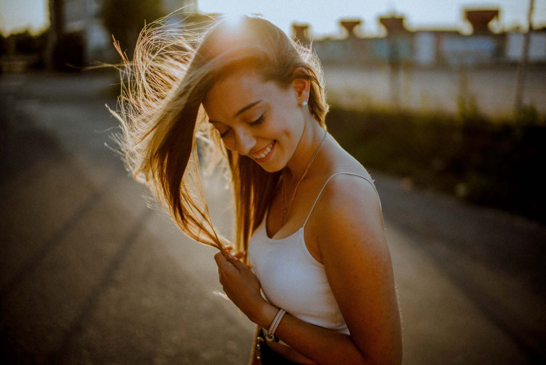 Haare wirbeln im Gegenlicht durch die Luft