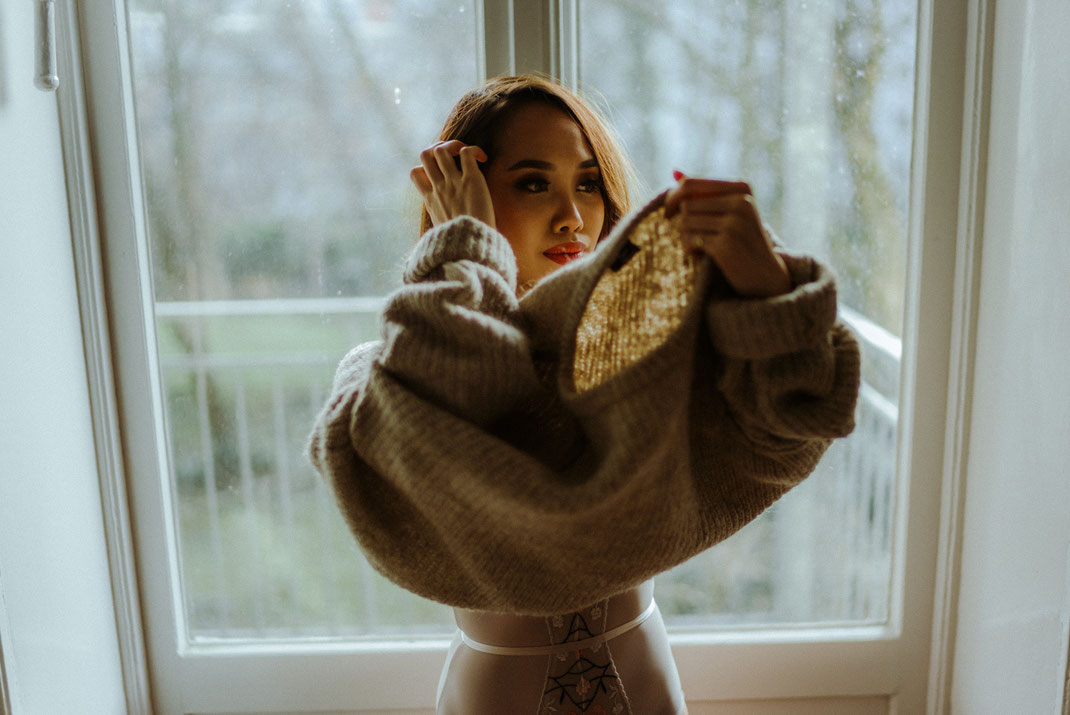 Junge Frau zieht ihren Pullover an