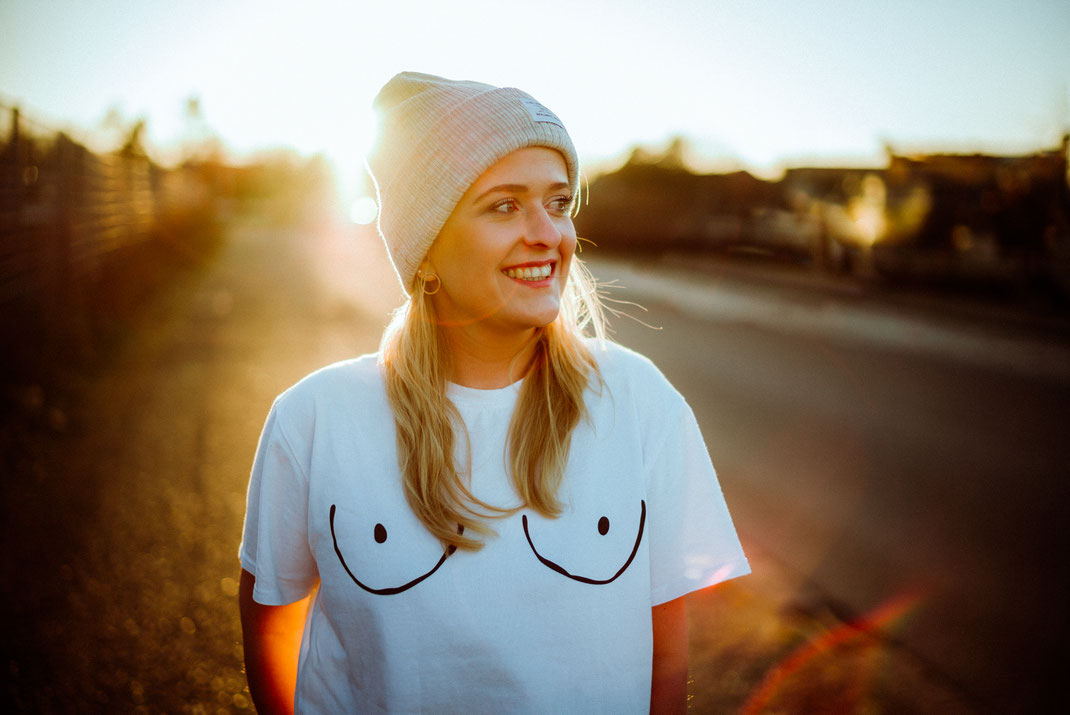 Junge blonde Frau mit mega coolem Print T-Shirt im Gegenlicht
