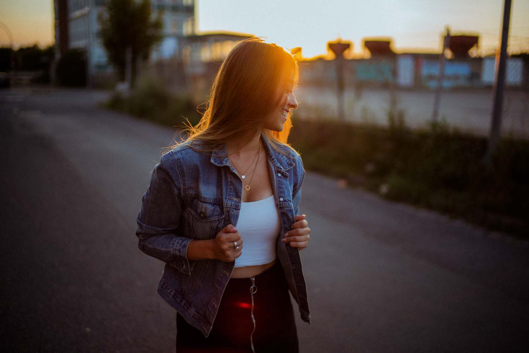 Frau mit Jeansjacke lächelt und blickt zur Seite