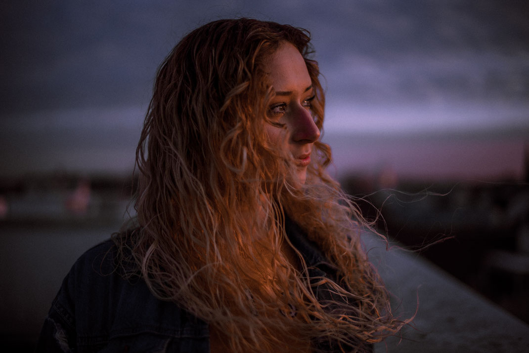 Frau schaut in die Ferne Haare wehen im Wind