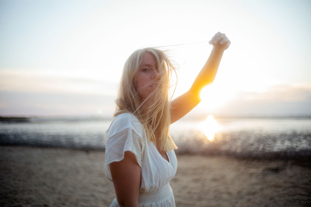 Frau im Gegenlicht am Strand