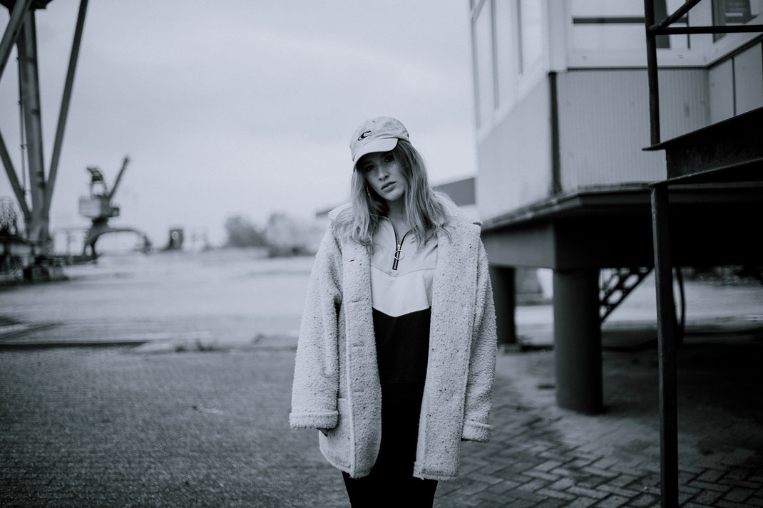 Junge Frau mit Mantel blickt in die Kamera Fotoshooting am Oldenburger Hafen