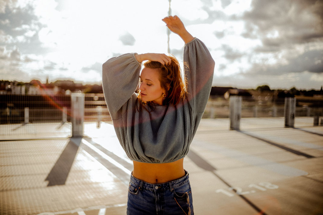 Junge Frau mit coolem Outfit blickt in die Ferne