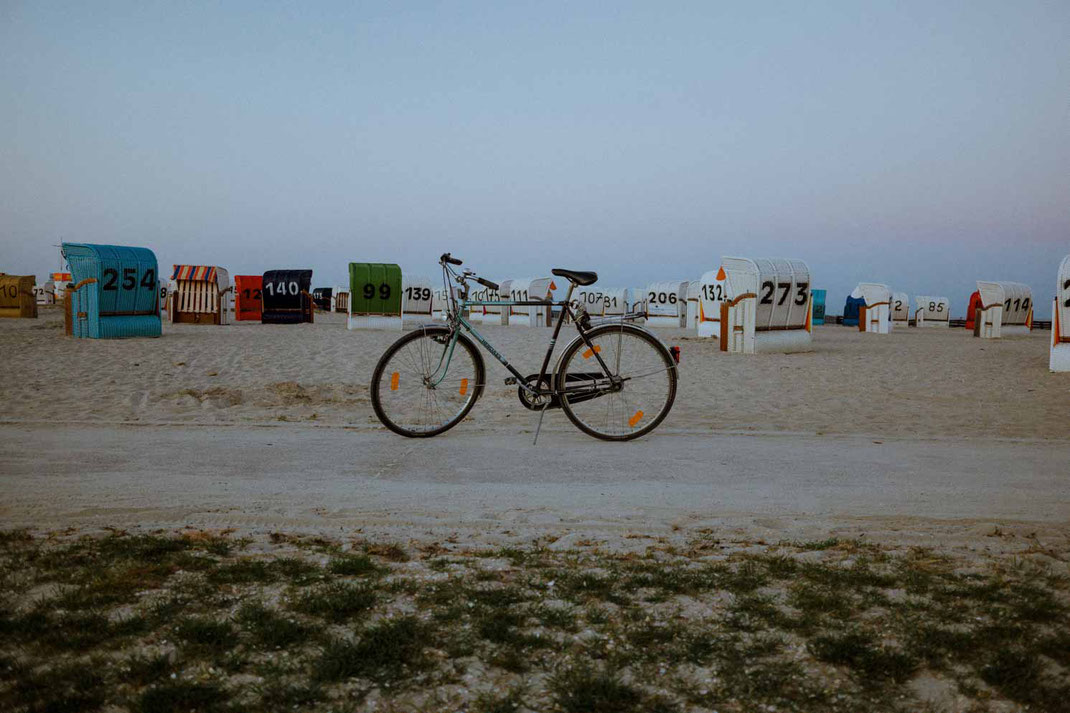 Altes Fahrrad am Strand im Hintergrund Strandkörbe