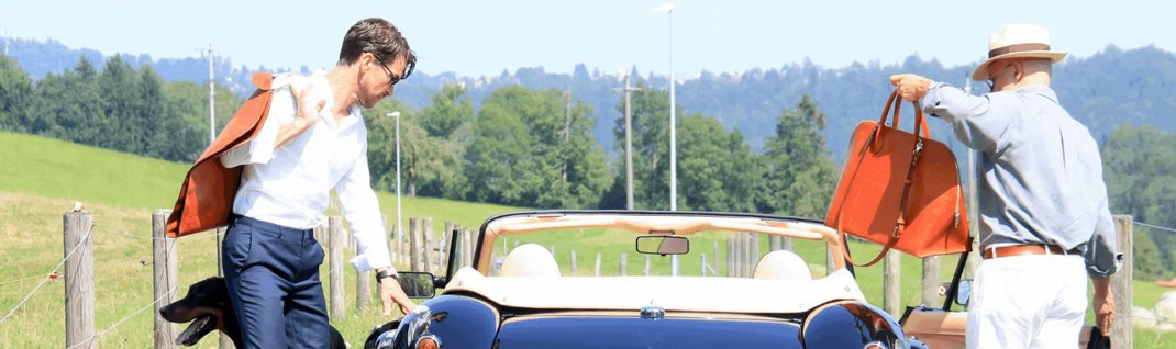 Lifestyle-Szene: Männer mit Ledertaschen von Götz an einem schwarzen Cabriolet