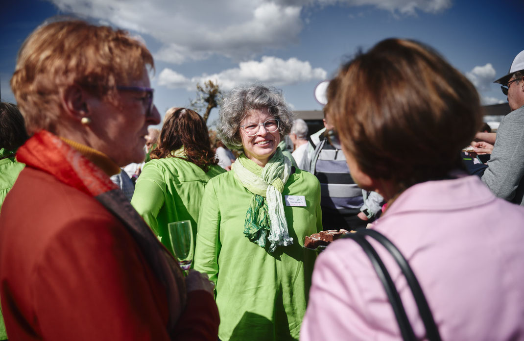 Eventfoto von Christoph Bastert: Teilnehmerinnen der LandFrauen-Veranstaltung auf der BUGA Mannheim 2023 im Gespräch, mit einer ehrenamtlichen Helferin in grüner Kleidung im Mittelpunkt.