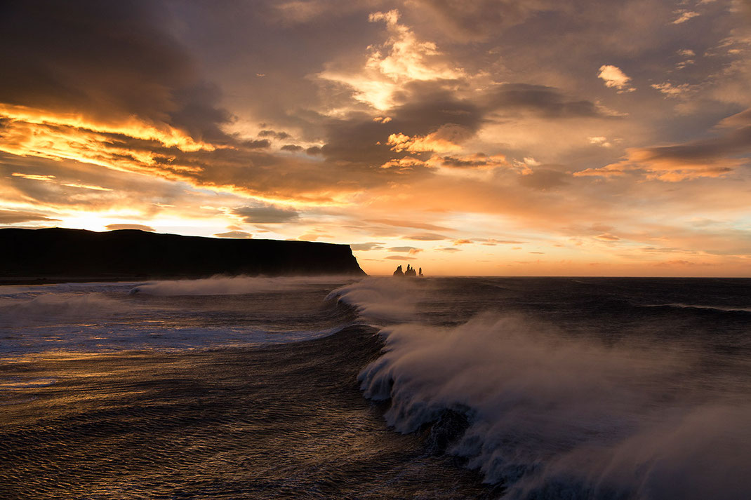 Beautiful red and orange sunrise with huge waves at the Atlantic Ocean at Dyrholaey, Vik i Myrdal, Iceland