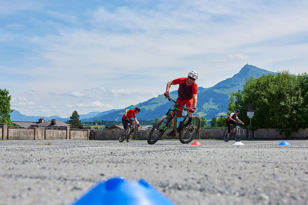 Mountainbike Übungen am Parkplatz, die vom Guide gezeigt werden. Eine Empfehlung an alle Mountainbiker.