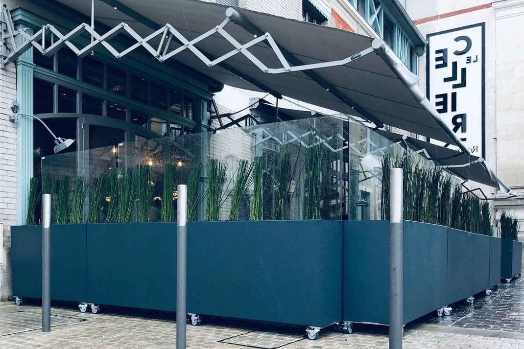 Mobile Windschutzanlage auf Rollen integrierten Pflanzkästen und ESG-Glas auf einer Restaurant-Terrasse