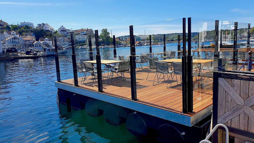 Transparenter Glas-Windschutz als Geländer an einem Bootsanleger mit Blick auf das Wasser