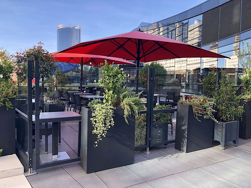 Windschutz-System mit klarem Glas in einer modernen Event-Location, bietet geschützte Außengastronomie mit stilvoller Glas-Element-Optik