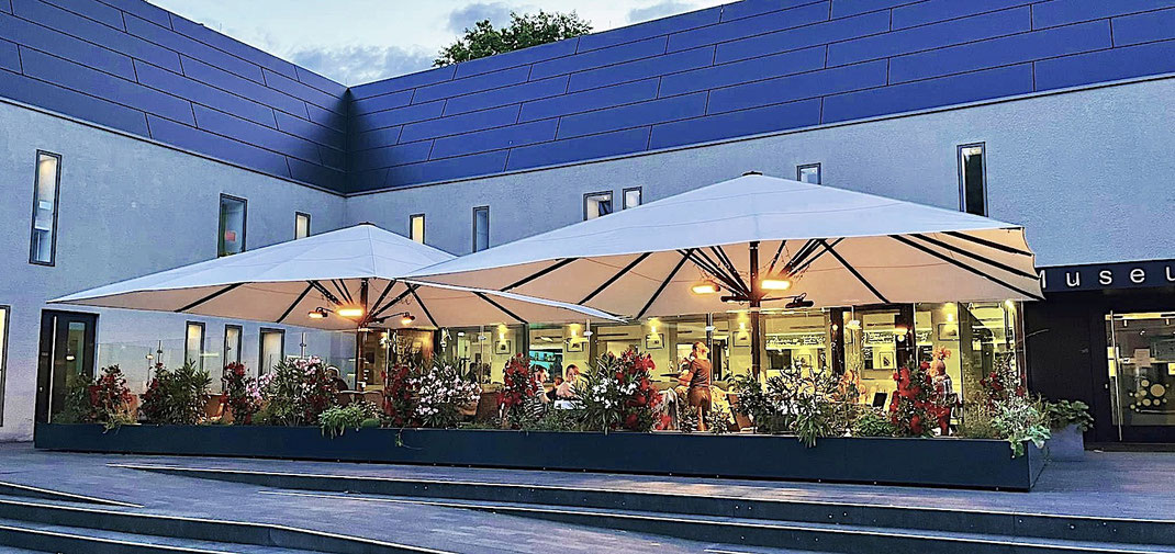 Biergarten mit einer Windschutzanlage und großen Sonnenschirmen