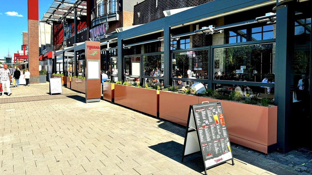 Außenterrasse eines Restaurants mit modernem höhenverstellbaren Windschutz aus Glas und Aluminium