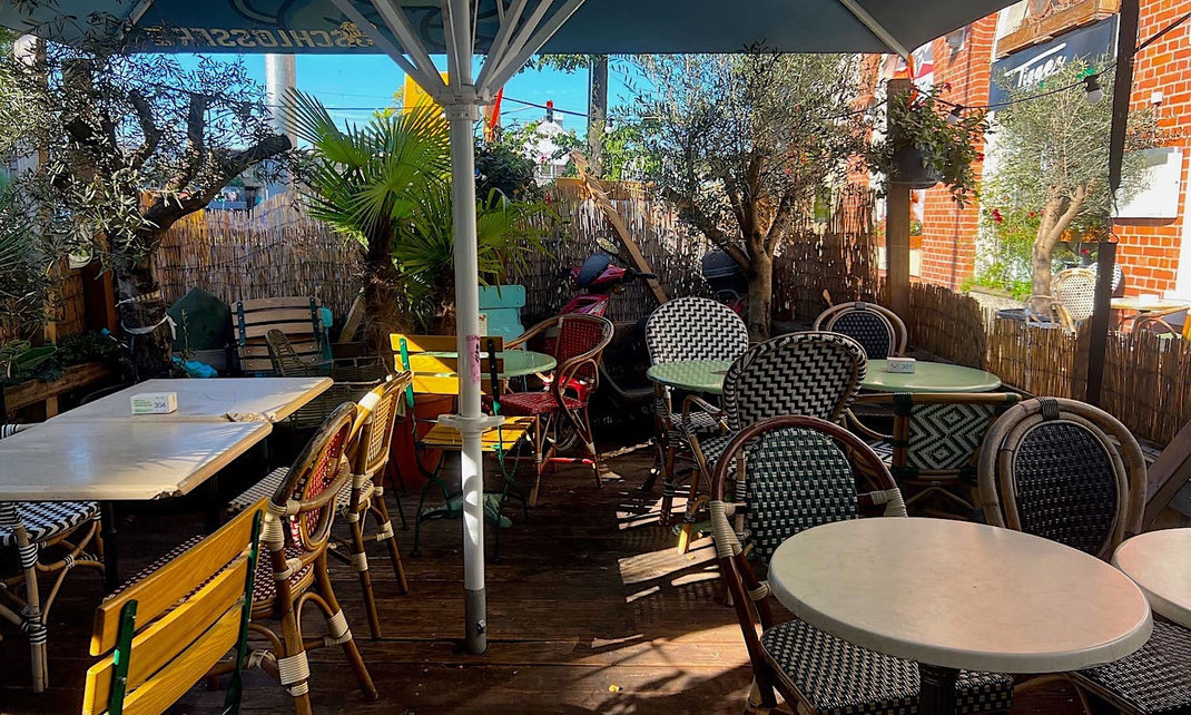Gastronomie Terrasse mit bunt gemischten Stühlen 