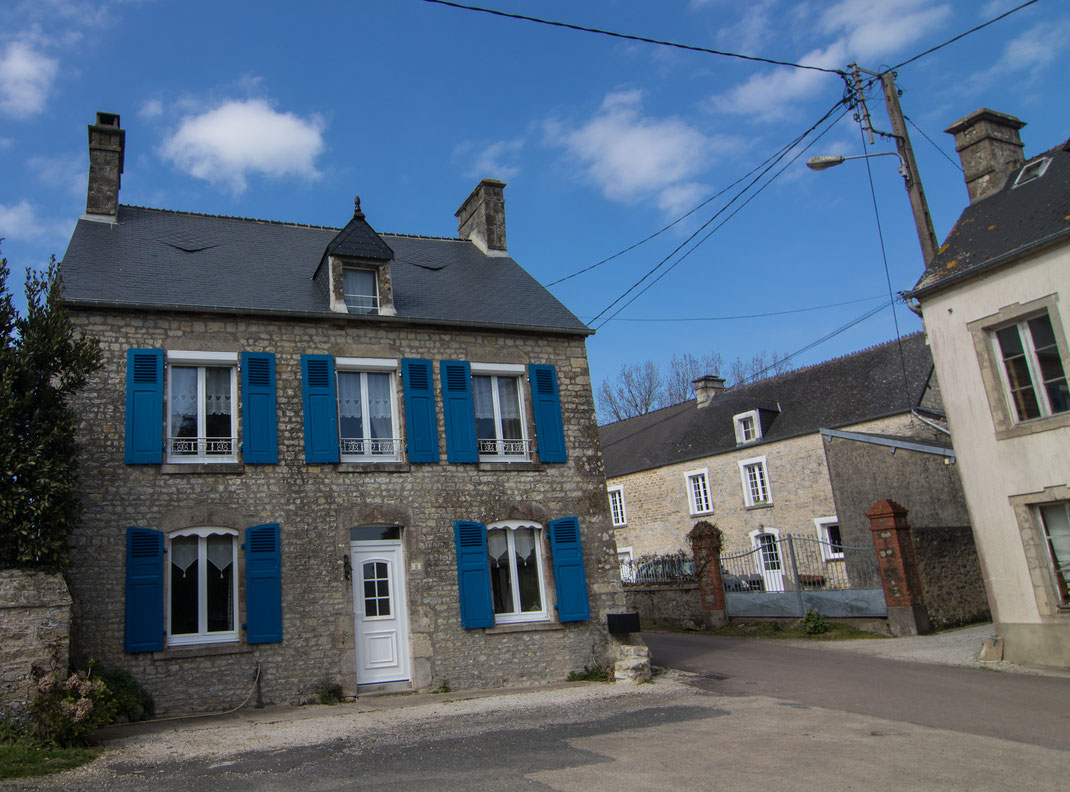 Ein Steinhaus auf der Halbinsel Cotentin in Fresville mit blauen Fensterläden