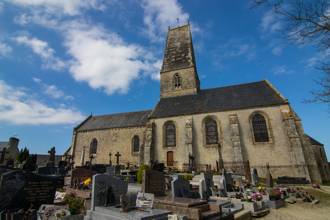 Eine alte normannische Kirche und der Friedhof in Fresville auf dem Cotentin.