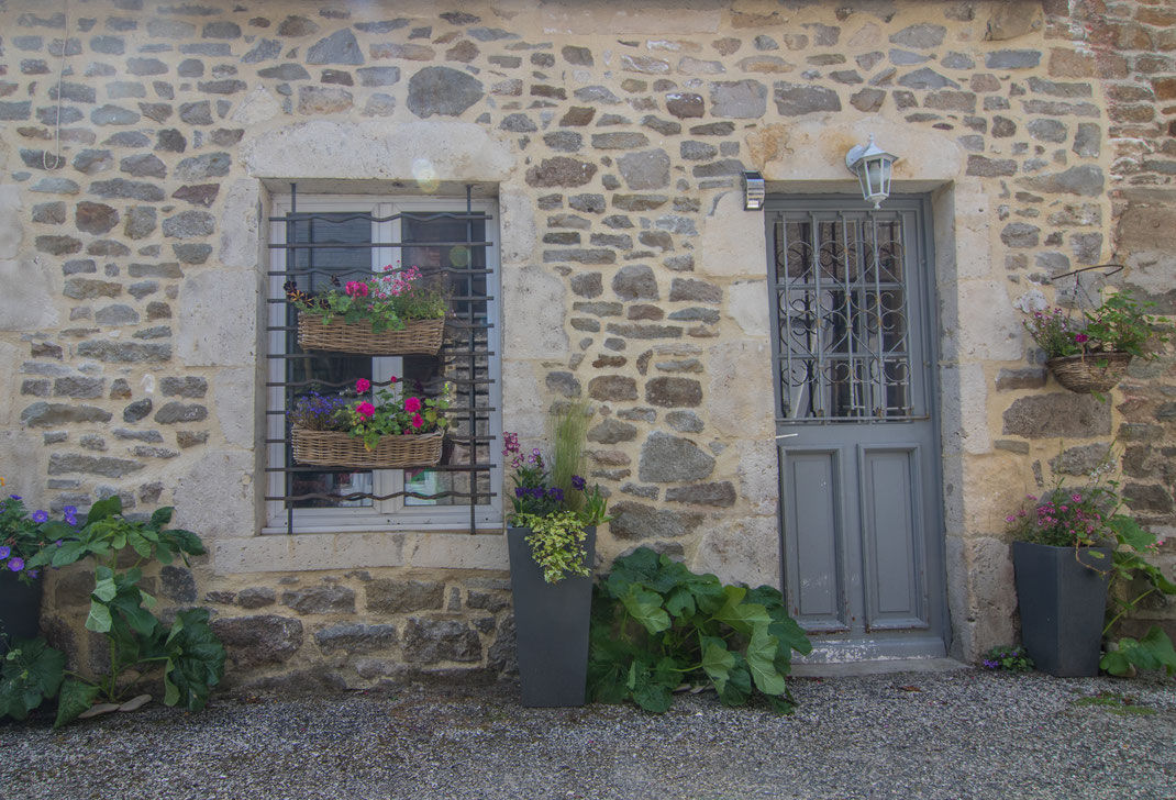 Tür, Fenster und Blumenschmuck eines Hauses in Saint-Vaastr-La-Hougue in der Normandie