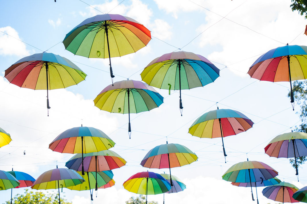 Colorful umbrellas hang from the sky in Green Jungle Park.