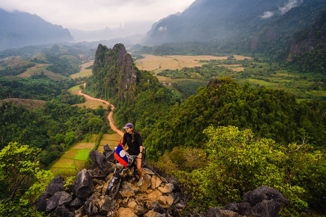 一名妇女坐在 Nam Xay Viewpoint 的摩托车上。