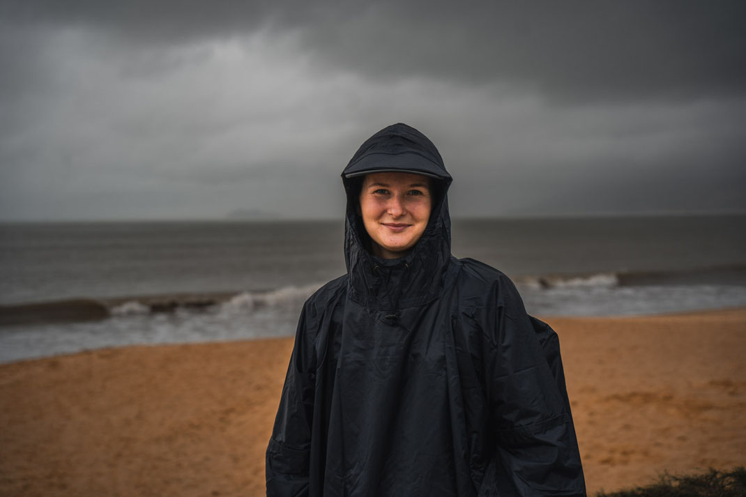 Eine Frau lächelt in die Kamera, hinter ihr die Küste von Quy Nhon.