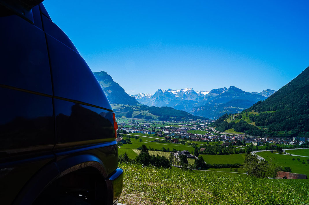 Alter VW-Bus und im Hintergrund die Berge der Schweiz.