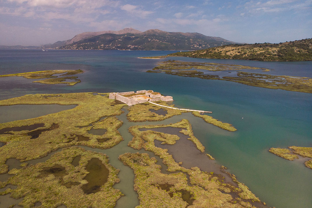 Drohnenaufnahme von der Burg von Ali Pacha mit dem Fluss und Bergen im Hintergrund.