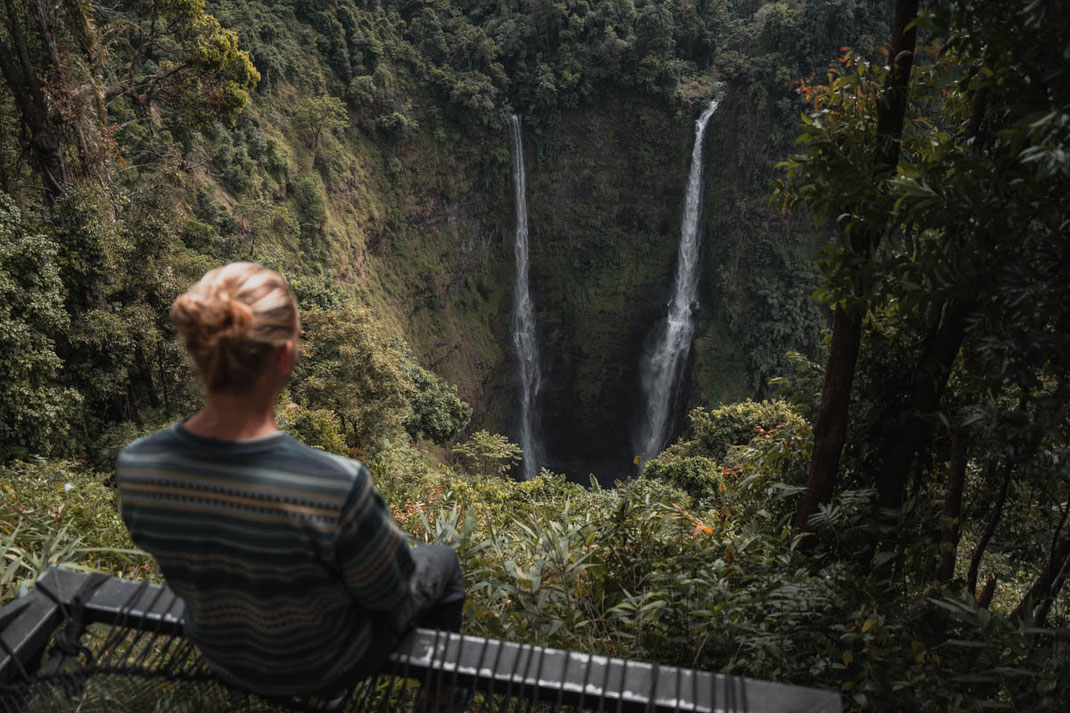 Un homme regarde en bas les deux ruisseaux de la cascade de Tad Fane.