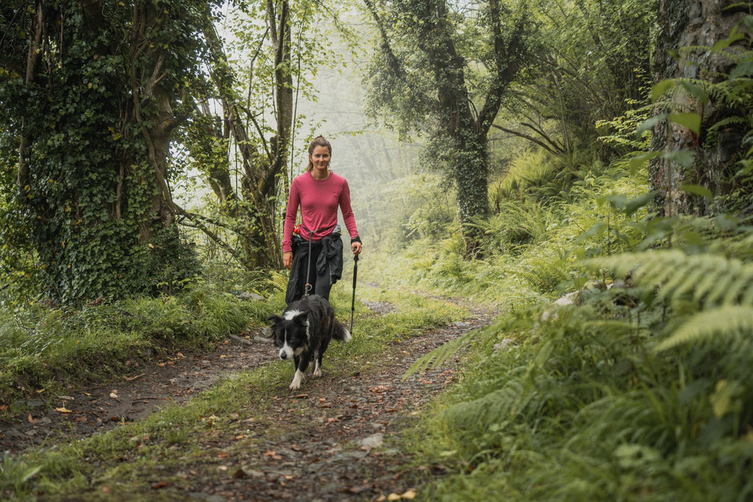 Eine Frau wandert mit ihren Hund durch die Gegend rund um Arenas de Cabrales.