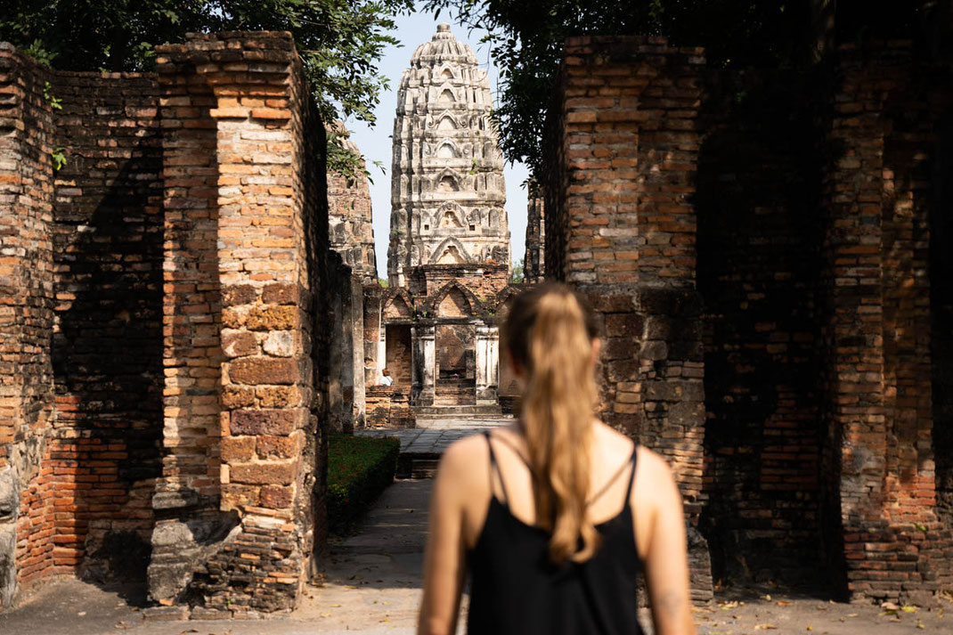 A woman strolls through the ruins in the historical park in Sukhothai.