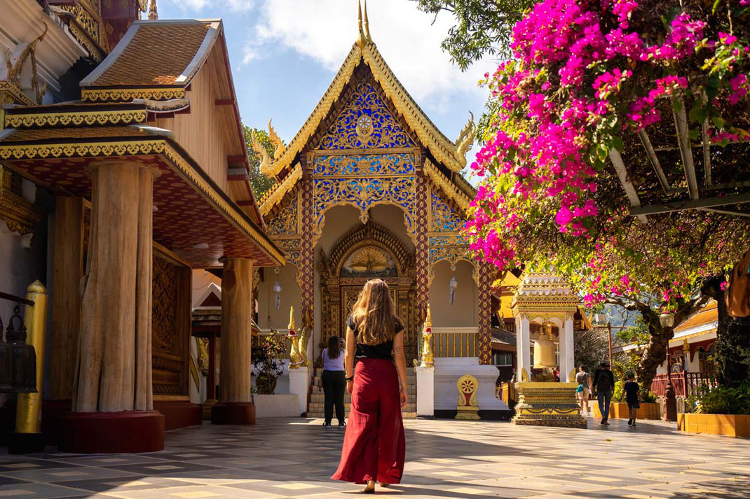 Une femme traverse une place remplie de gens à Chiang Mai.