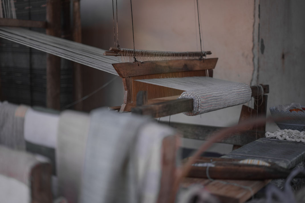 Close-up of a loom with cloth clamped.