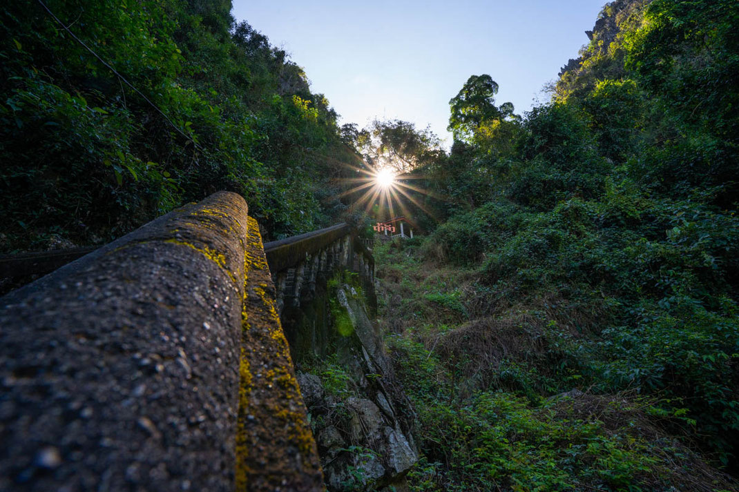 Eine steile Steintreppe führt zum Sonnenuntergang hinauf zur Tham Chang Cave in Vang Vieng.