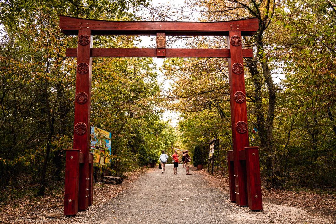 Das rote Eingangstor zur Fiedens Stupa muss durchschritten werden, um zum durch den bewaldeten Park zum Tempel zu gelangen.