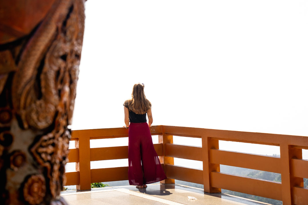 Una mujer observa la ciudad de Chiang Mai desde un parapeto.