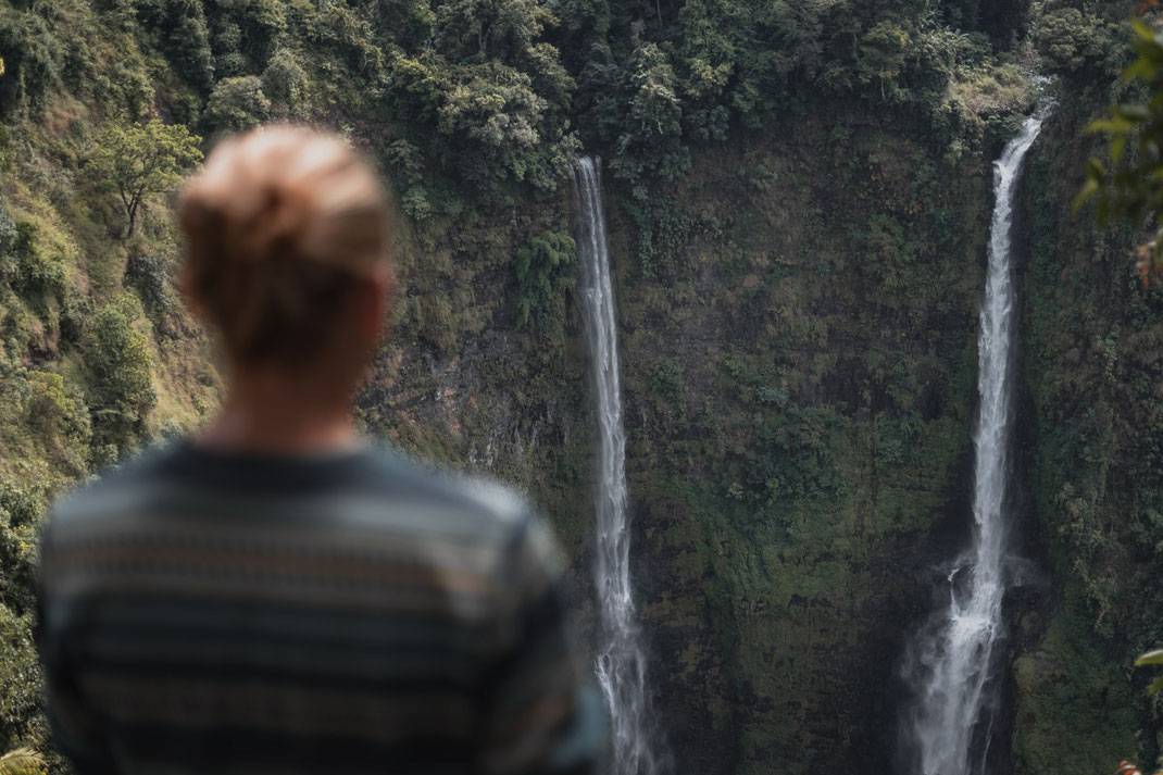 Un hombre contempla los dos arroyos de la cascada de Tad Fane.