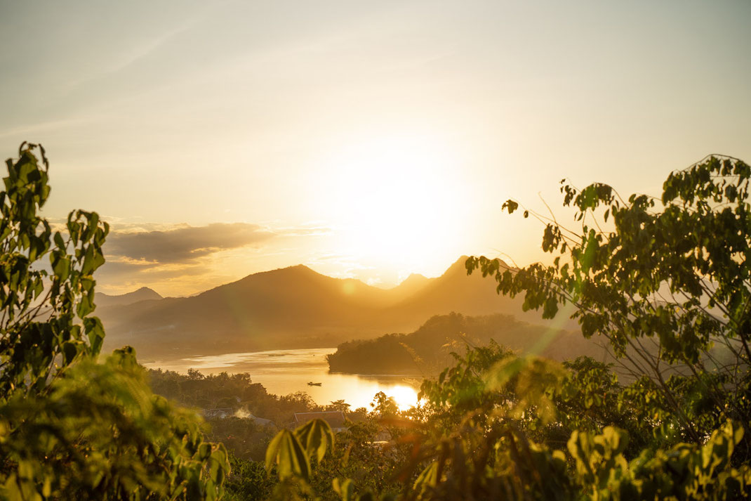 Coucher de soleil sur le mont Phou Si avec vue sur le Mékong et les montagnes.