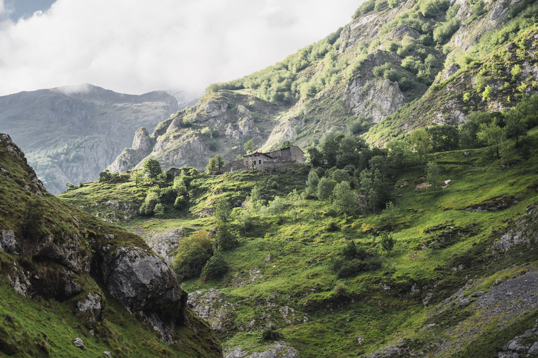 Die ersten Häuser des Bergdorfes Bulnes werden sichtbar im Nationalpark Picos de Europa.