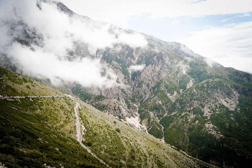 Passstraßen von der Küste Albaniens zum Llogara Nationalpark mit schroffen, wolkenverhangenen Berggipeln.