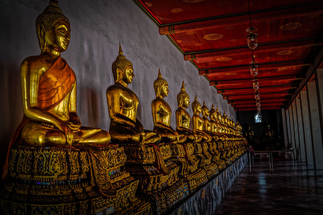 Golden Buddhas sitting in a row at Wat Pho.