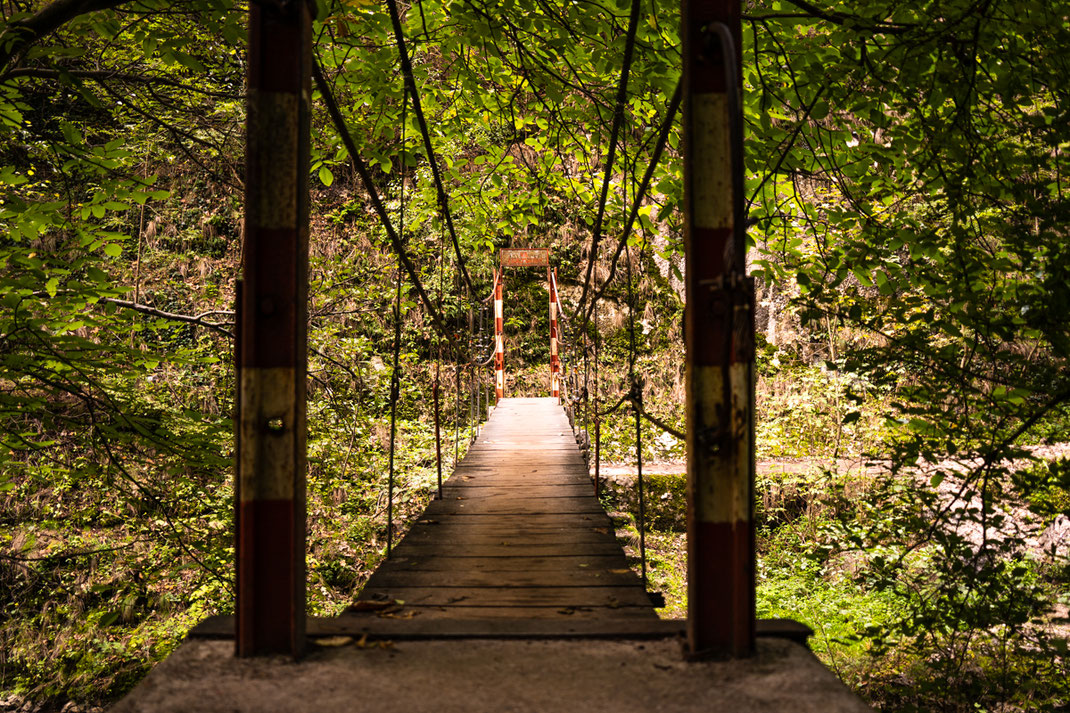 Eine massive Hängebrücke führt in der Thorenburger Schlucht über einen Bach.