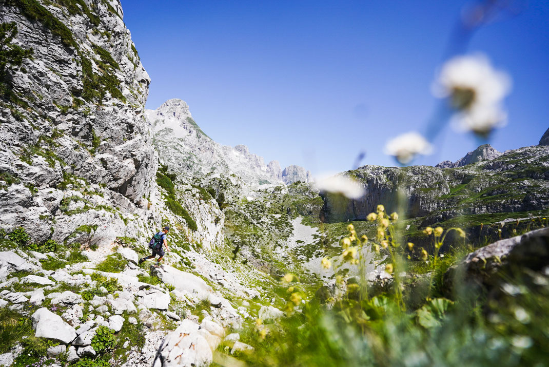 Mann wandert am Peja Pass in Richtung See.