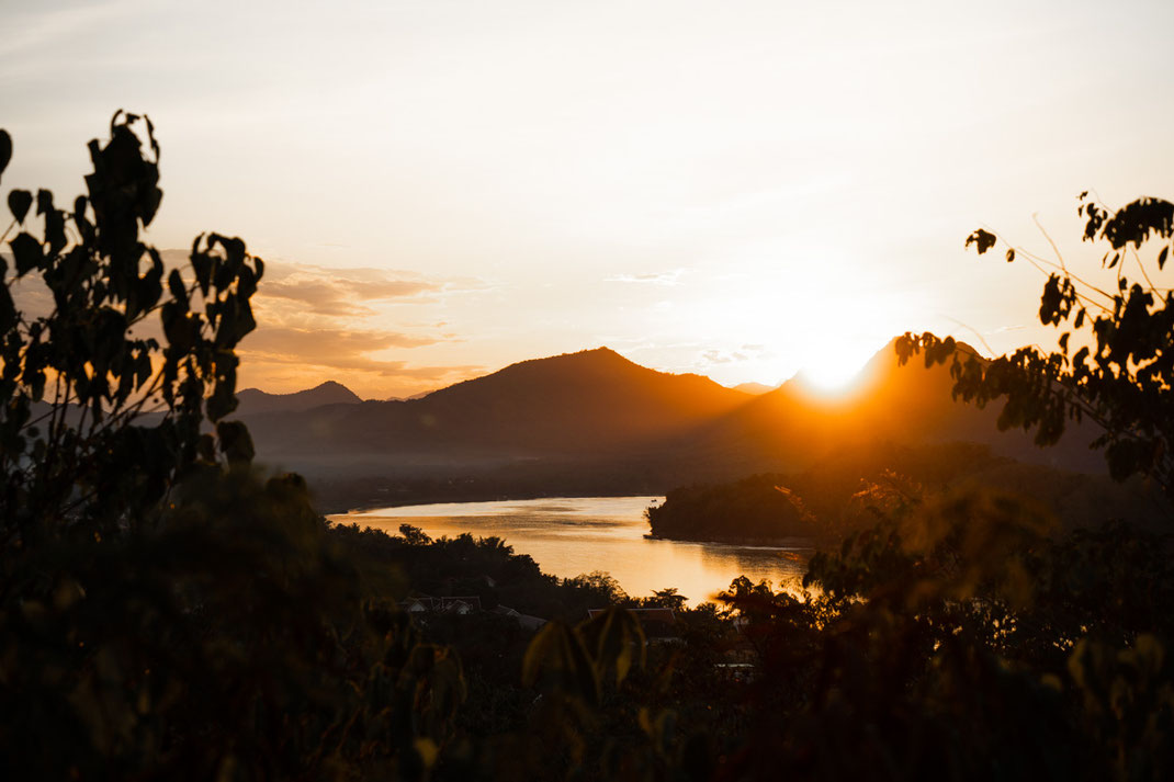 Sunset at Mount Phou Si with the Mekong River and the surrounding mountains.