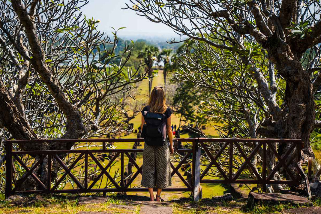 A woman looks down the long path to Vat Phou.