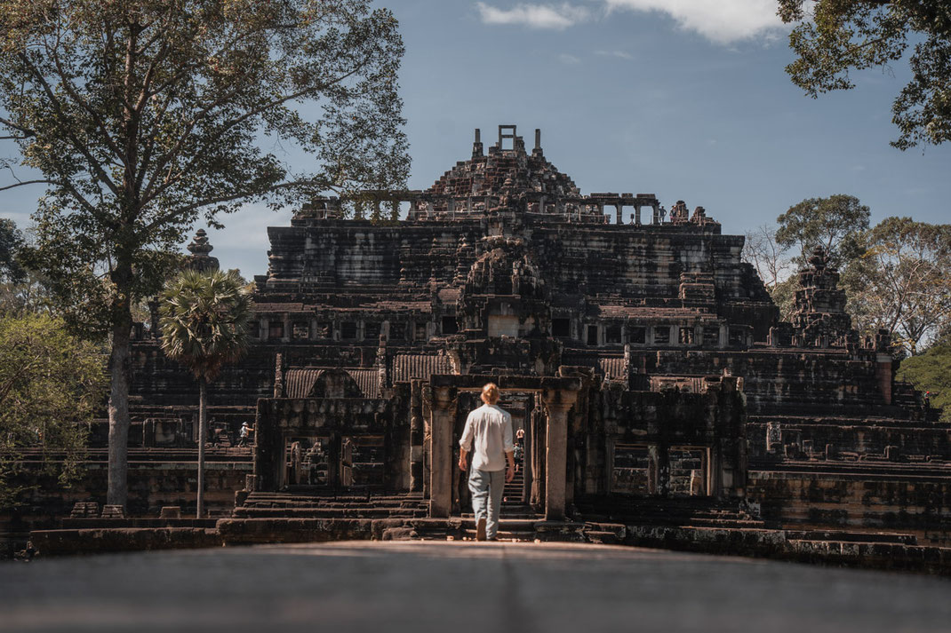 A man walks towards a temple in Angkor.