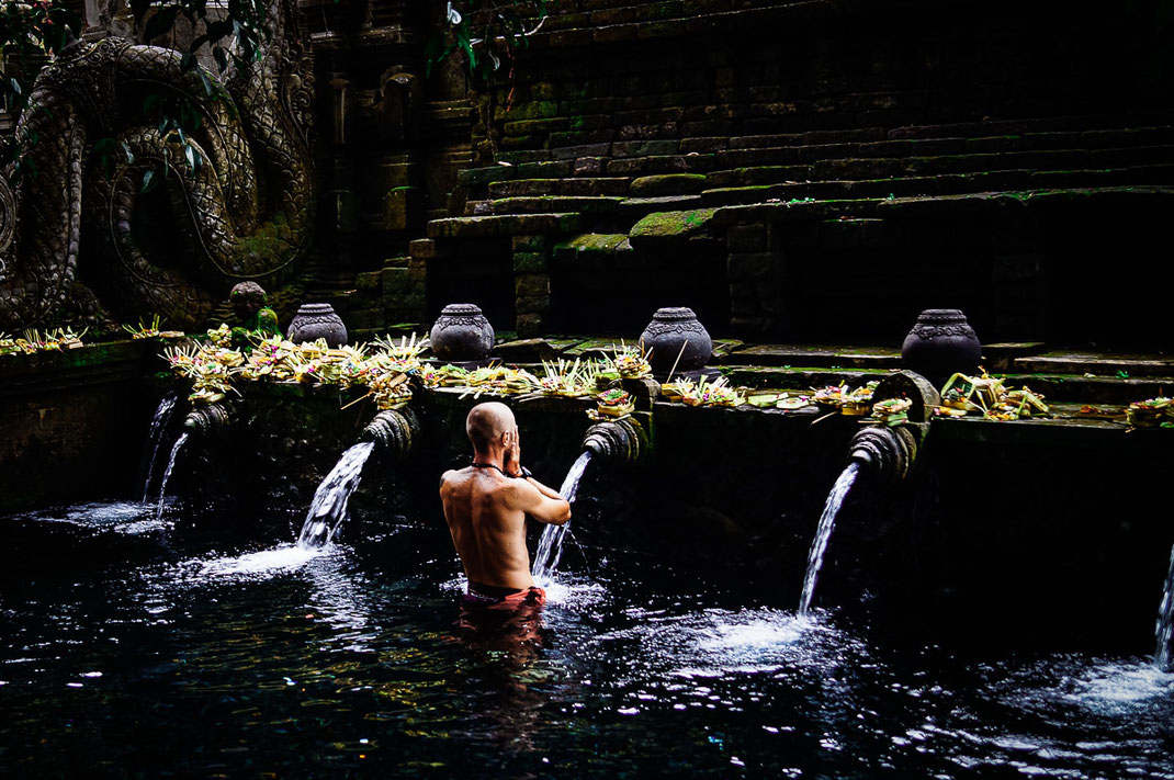 Single man performing ritual ablution at Pura Tirta Empul.