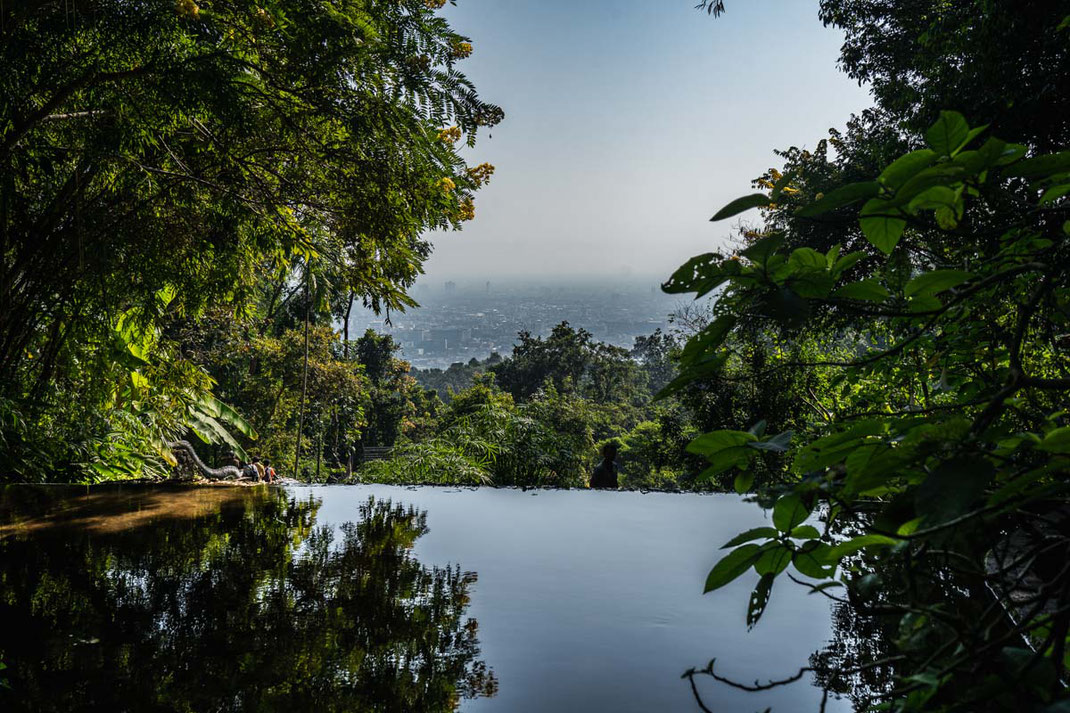 Una pequeña cascada baja borboteando con vistas a la ciudad de Chiang Mai.