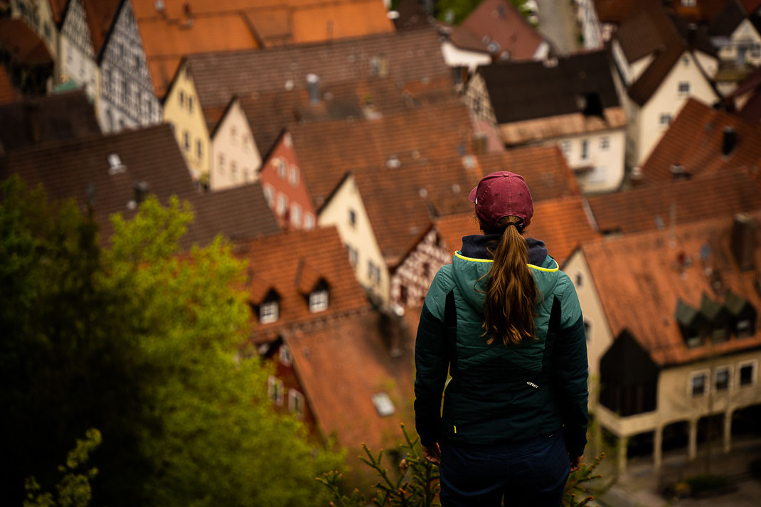 Frau blickt auf die Stadt Pottenstein und deren Fachwerkhäuser.