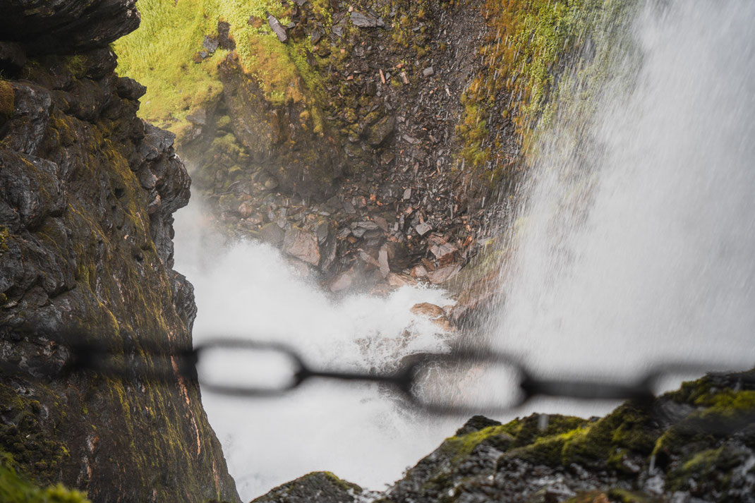 Eine Kette trennt den felsigen Weg vom Abgrund direkt hinter dem Wasserfall Storseterfossen.