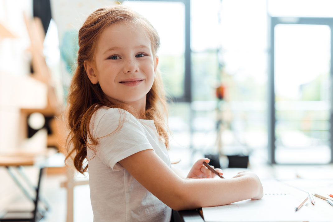 Kind im Kindergarten beim Basteln für den Portfolio Ordner.